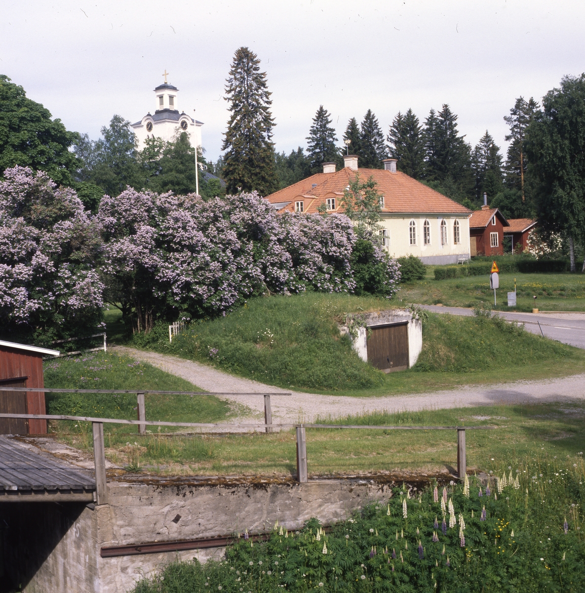 Rengsjö församlingshus med kyrkans torn i bakgrunden, juni 1999.