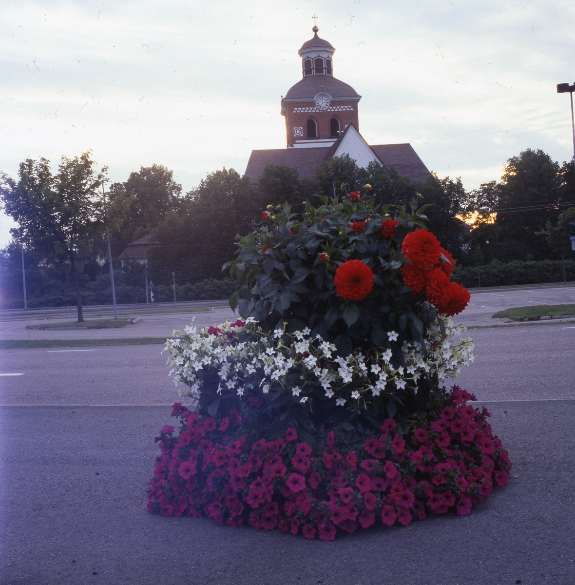 Praktfull blomsterurna med kyrkan i bakgrunden, Bollnäs 25 augusti 2001.