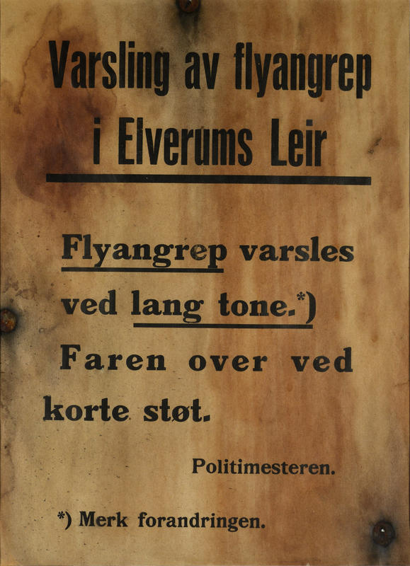 Plakaten blir hengt opp på en bjørk i Elverum sentrum for å varsle befolkningen. Den er tydelig merket av bombingen i 1940. Plakat utlånt av Marit Hjorth Høivik.