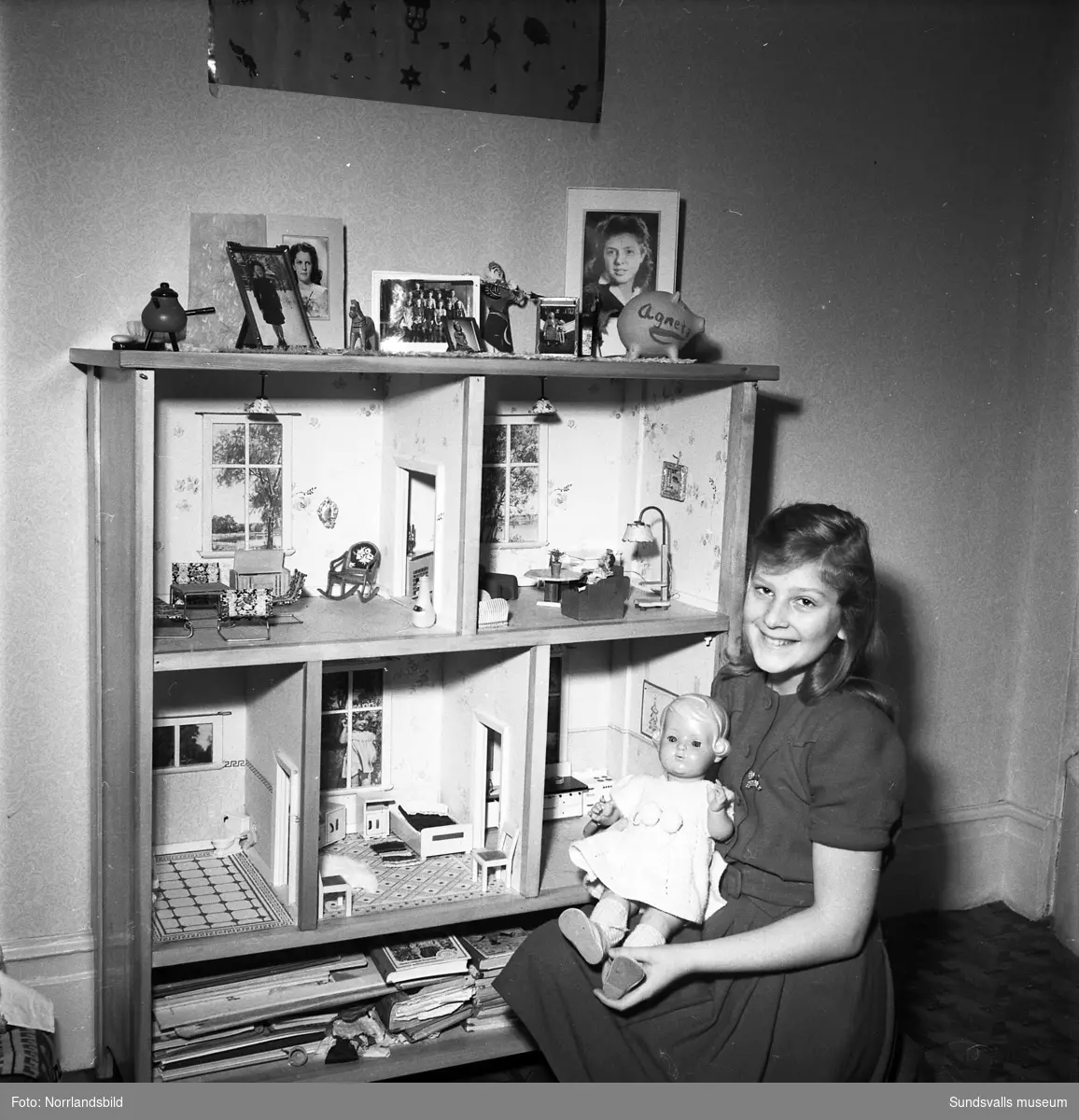 Interiörbilder från hemmet hos fru Maja Rösiö. På första bilden en flicka (Agneta) invid ett vackert dockskåp.