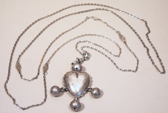 Halsband med smyckehänge i vit metall. Hjärtformat med tre hängande kulor.