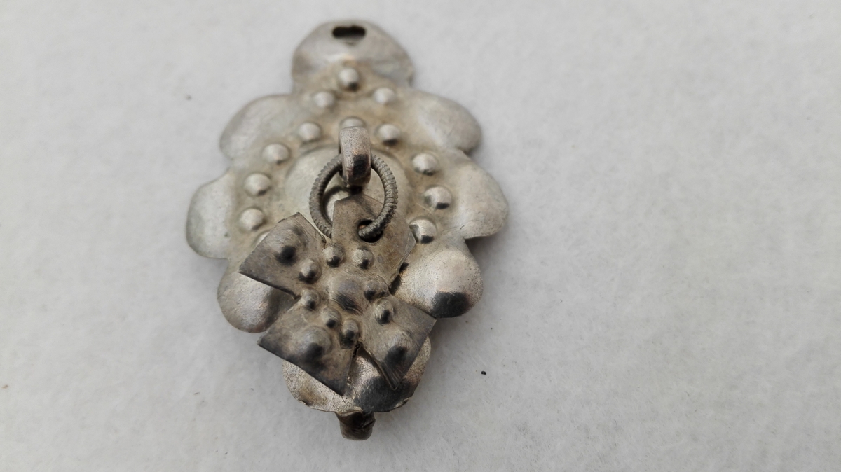 Form: Utpoklet sølvplate med korsforma lauv.
