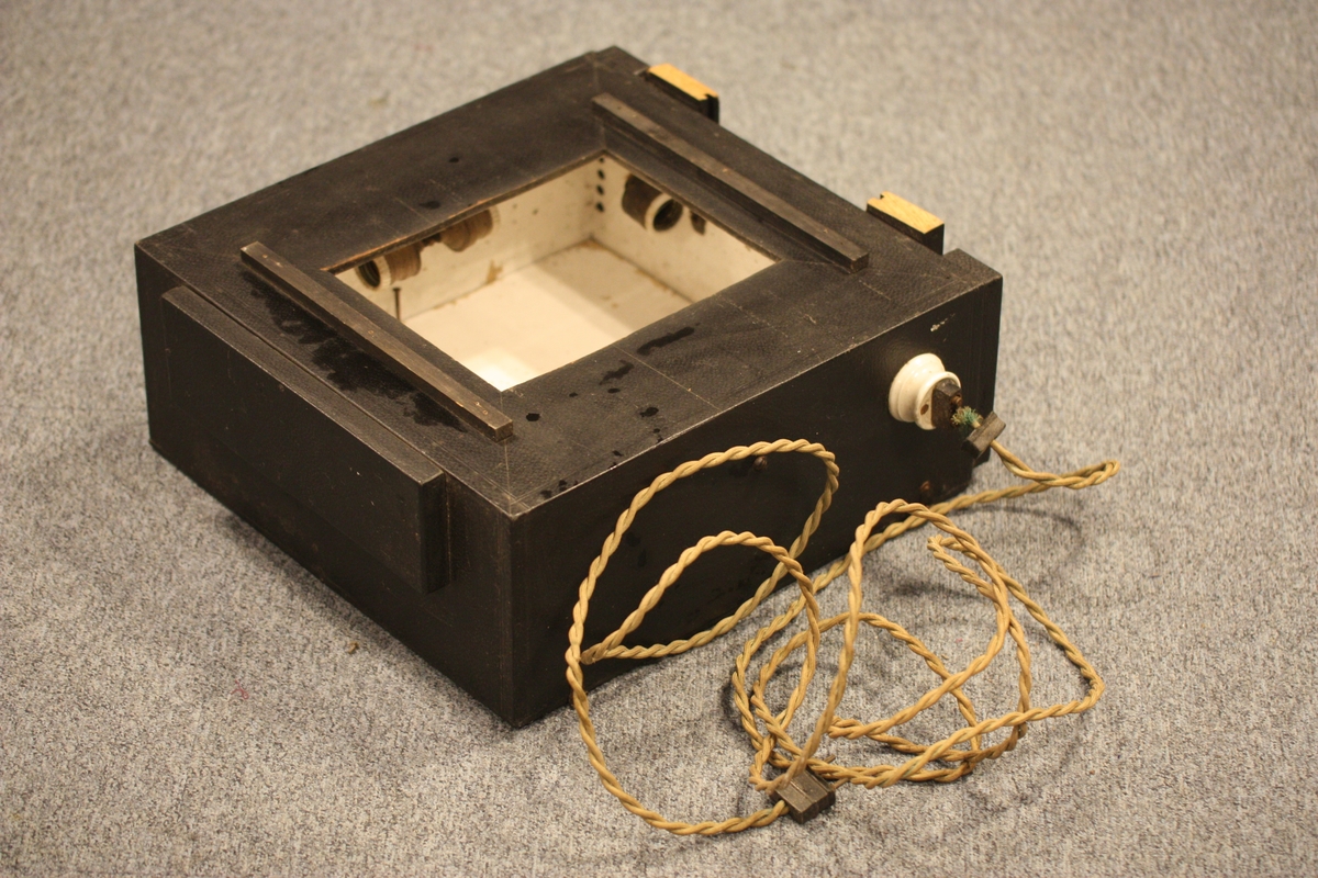 Kvadratisk kasse med innlagt elektrisk ly, til saman 6 lyspærer. Opning til glasplate på eine sida. Motsett side kan takast av for å få tilgang inn i kassa.