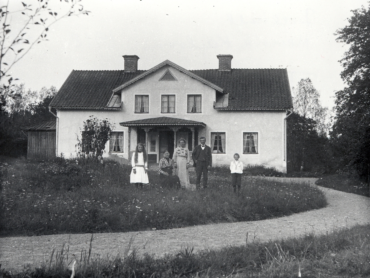 Familjen framför bostadshuset på gården Bredshult.