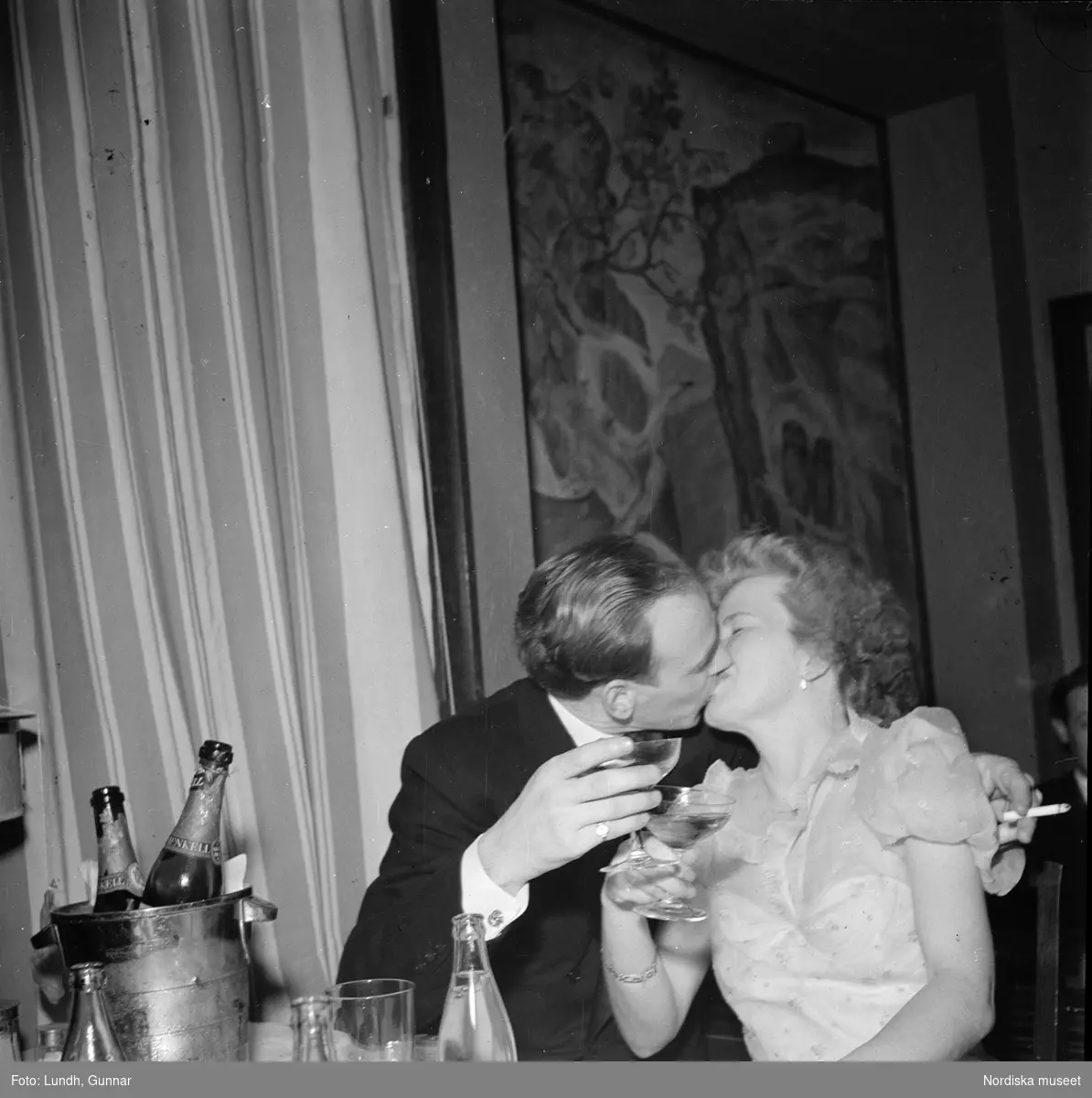 Nyårsfirande på Hedmans hotell, Hålland utanför Åre. Ett kyssande par sitter vid ett bord med champagneflaskor i en ishink.