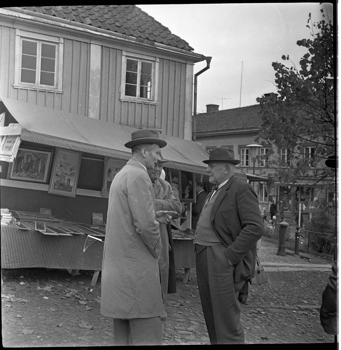 Marknad på Gränna torg. Konstförsäljare vid torgets södra del. Framför densamma står Ernst Karlsson från Kaxtorp i mitten och Artur Karlsson från Vendelstorp till höger. Mannen till höger är oidentifierad.