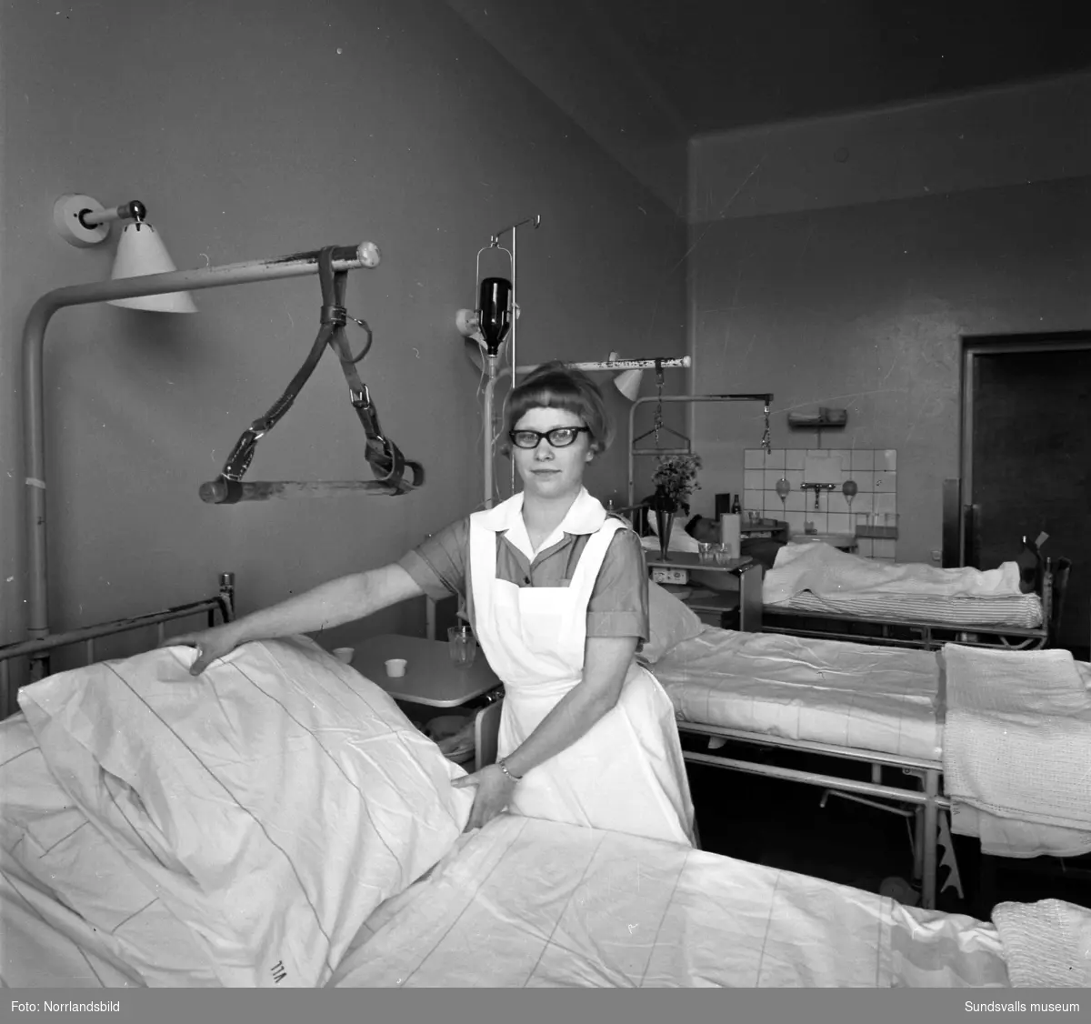 Ett vårdbiträde bäddar en sjuksäng på Sundsvalls sjukhus.