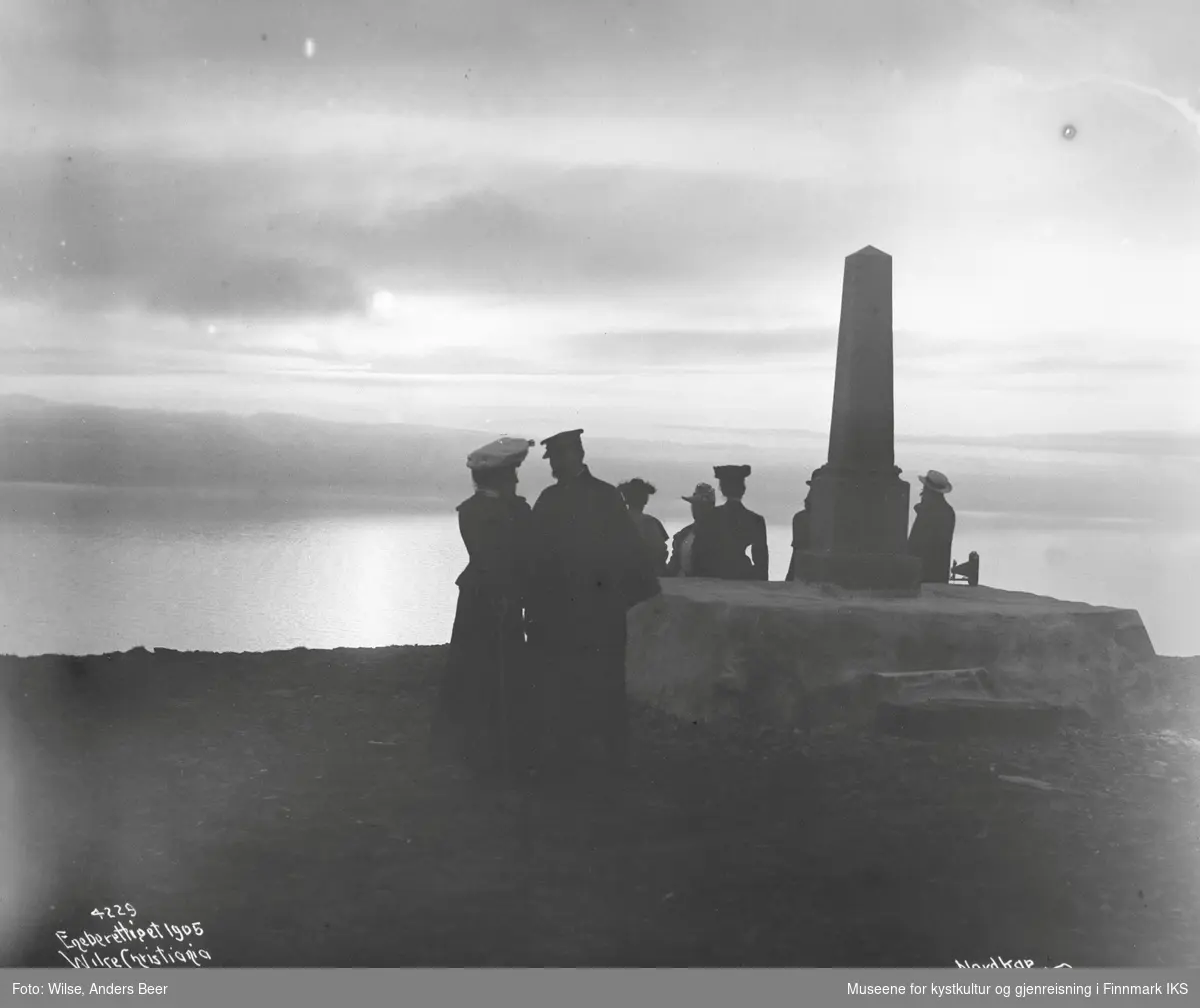 Midnattsol. Turister ved Oscarstøtten på Nordkapp-platået. 23.07.1906. (Originalnegativet eies av Norsk Folkemuseum, W 04229)