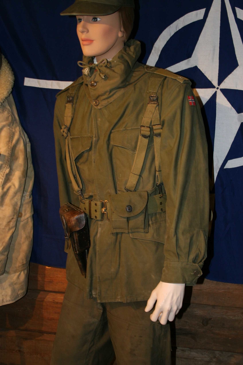 Uniformen består av bukse og jakke med hette. Jakke har knepping forran og rundt håndledd. 4 lommer forran og skulderklaffer med distingsjoner.