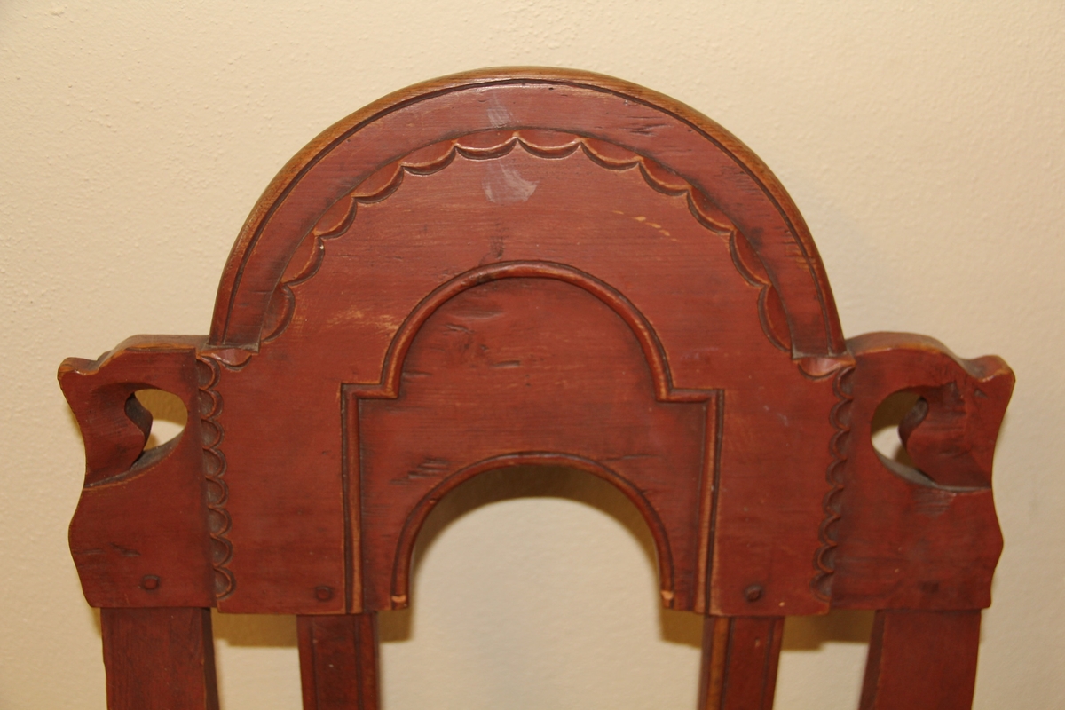 Rødbrun stol av tre med rokokko-elementer