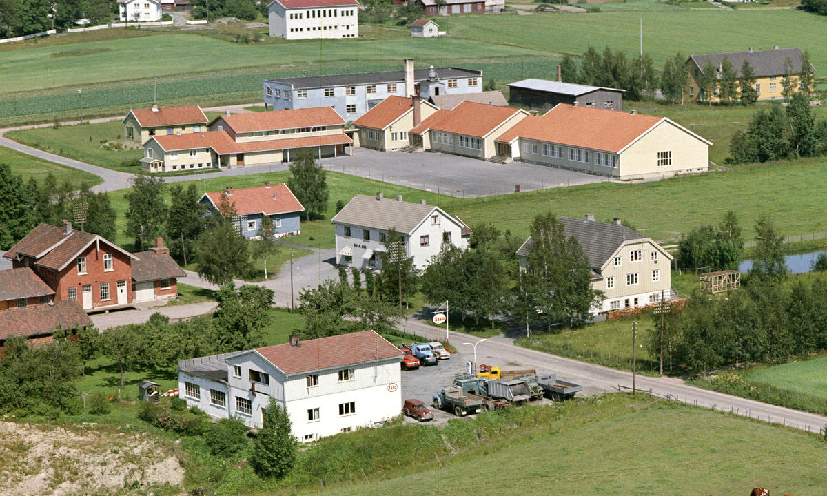 Foto tatt fra luften av hus med jorder rundt.