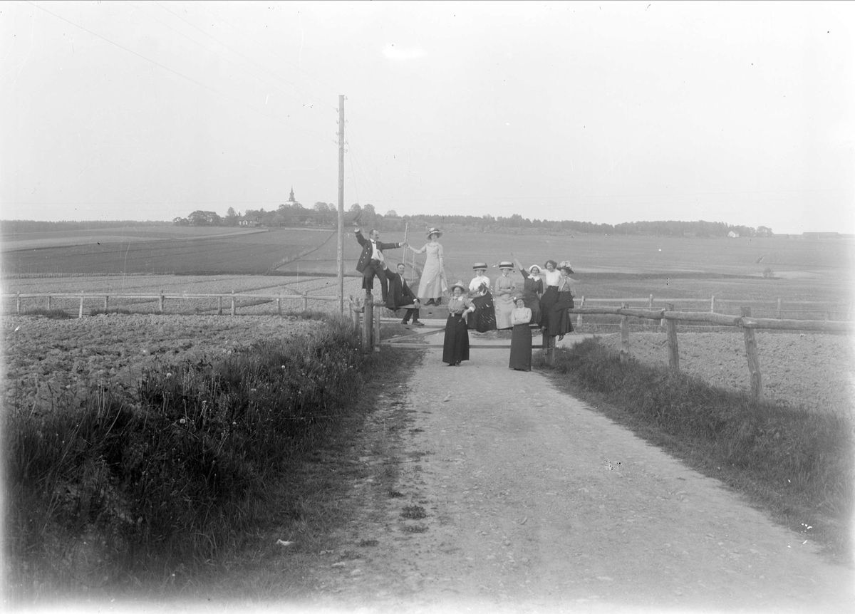 En grupp människor på grind vid landsväg