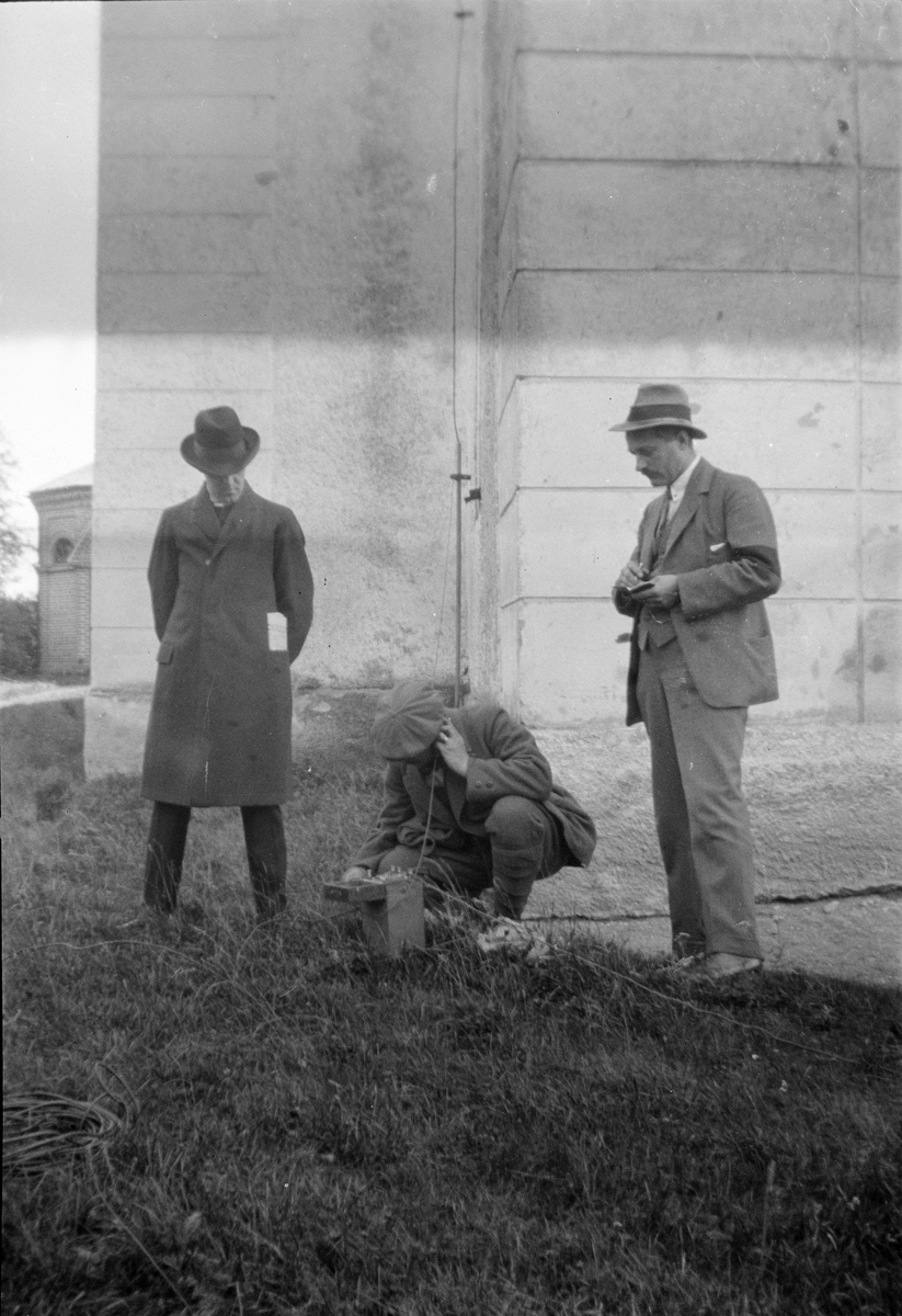 Tre män med radioapparat utanför Altuna kyrka, Uppland 1926