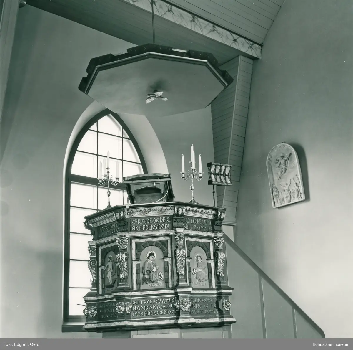 Text till bilden: "Tegneby kyrka. Predikstol från 1600-talet. Hårt restaurerad. Till höger i bilden gipsrelief gjord 1890 av Carl Johan Dyfverman för altaruppsatsen".