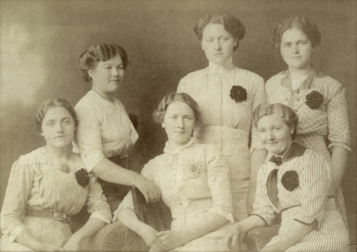 Portrett av seks kvinner som arbeidde på Salhus Tricotagefabrik, tatt i høve fødselsdagen til kvinna i midten framme.