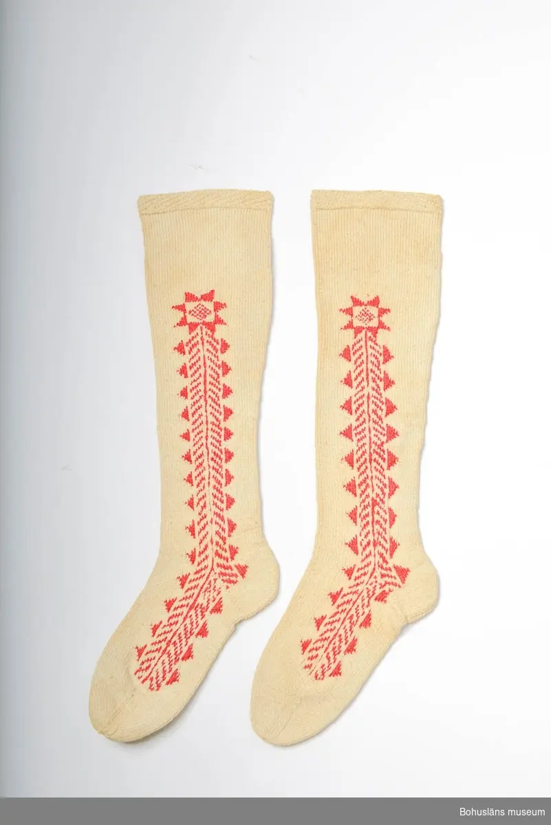 Handstickade strumpor av bomullsgarn. Vita med instickat geometriskt mönster i rött längs fötterna och upp på skaften, på båda sidor.
Slätstickade med en kant mönstrad av aviga och räta maskor i diagona ler överst. Märkta UM 4:C:I och II.
Enligt Knut Adrian Anderssons katalog I:5:4, D 2 A:1 i museets arkiv, är strumporna "stickade ur minnet av en gammal kvinna på Inland i början av 1900 talet".
I samma katalog står även att de vita strumporna skänkta 1910 av Bertha Kleberg är stickade av "gummor på Inland".
Svagt brungula fläckar på många ställen (rost?). Gulnade.
Strumporna diskuteras och är avbildade i Centergran (2010) s. 27-28.

Litteratur om Bertha Kleberg och om revitalisering av bygdedräkter:
Arill, David, Bertha Kleberg och Bohusdräkten ur Bohusländska folkminnen Studier och uppteckningar red Arill, David, Uddevalla 1922.
Centergran, Ulla, Folkdräktsrörelsen i Bohuslän och Göteborg, C-uppsats i etnologi, Göteborg 1973, Bygdedräkter bruk och brukare, Göteborg 1996. 
Centergran, Ulla. Bohusdräkter. Tolkningar under ett sekel. Bohusläns museum och Bohusläns hembygdsförbund, nr. 71. Bohusläns museums förlag. Andra upplagan 2010. 
Wistrand P G, Bohusländska folkdräkter ur Fataburen häfte 1 1908.
Omkatalogiserat 1997-03-20 VBT

Enligt uppgifter på diarienummer 184/69 KVINNLIGA DRÄKTPLAGG FRÅN BOHUSLÄN TILL UDDEVALLA MUSEUM: Strumporna 4a, 4b, 4c är stickade av gummor på "Inland" i början av 1900-talet. ...

Ur handskrivna katalogen 1957-1958:
Strumpor 3 par.
a) Ett par a) 1-2 L. c:a 62 cm;röda, ylle, stickade m. resår i skaftets översta del; malhål. 
b) ett par b:1-2; L. c:a 67 cm, ylle, vita m. instickade röda kilar; malhål. 
c) Ett par c: 1-2; L. c:a 55; vita, bomull, m. instickade  röda kilar, några rostfläckar. 

Lappkatalog: 78