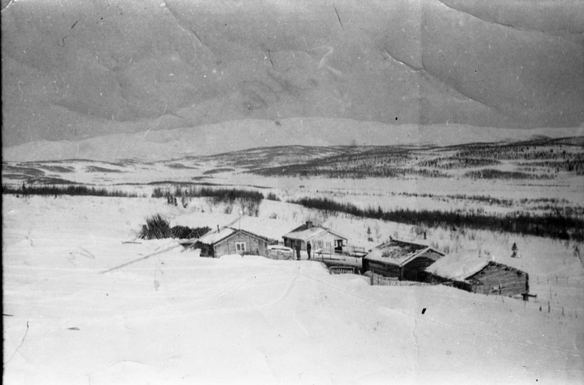 Avfotografert bilde av hytte-/stølsområde i vinterdrakt. Stedet er ikke identifisert.