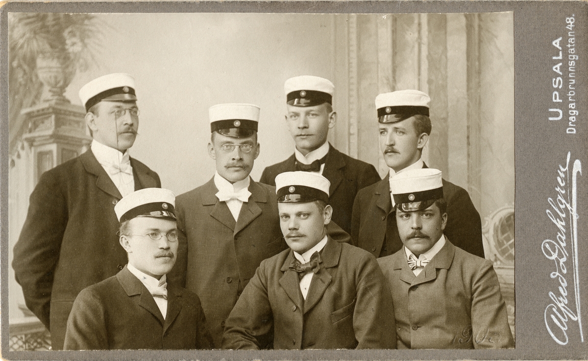 Kabinettsfotografi - sju män iklädda kostym och studentmössa, Uppsala 1903