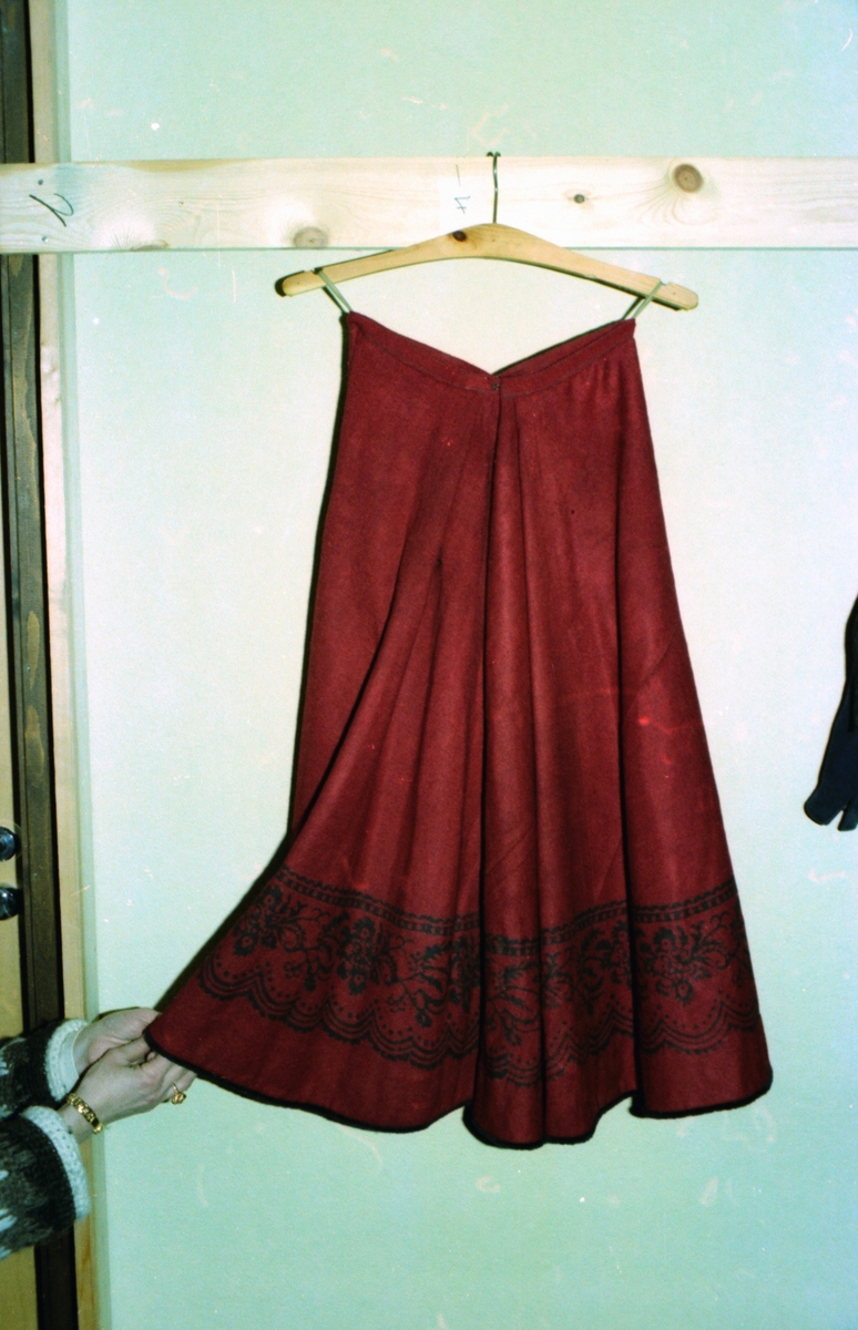 En rød understakk med trykt bord fra Karen Gjerde, Rem. Motiv tatt ved ei tekstilutstilling i Valldal.