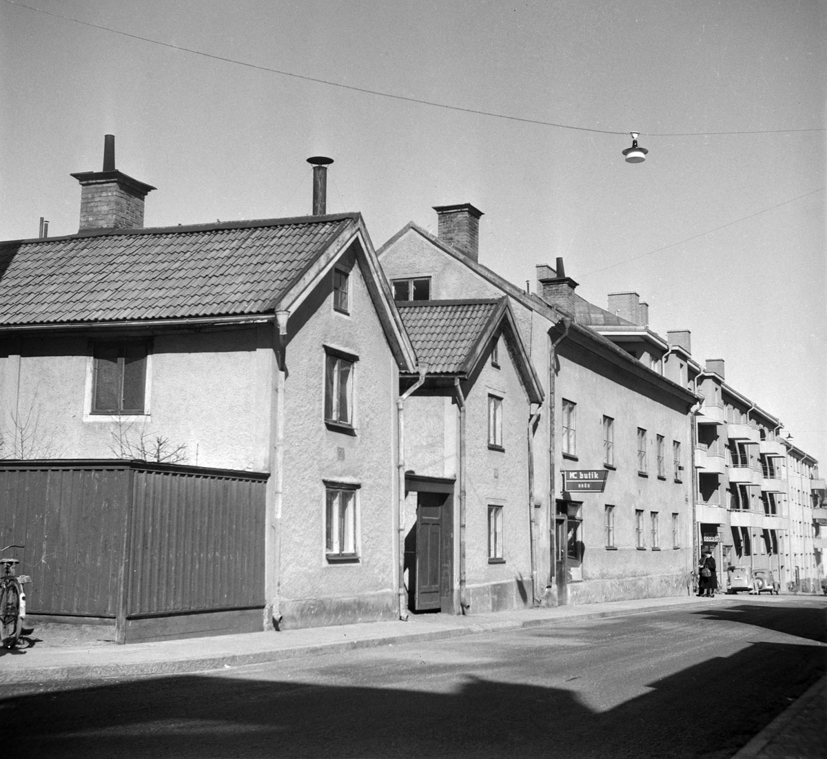 Smedjegatan 39 - 43 i kvarteret Karbinen, Norrköping. Byggnaderna i båtshusmanstil var byggda 1839 respektive 1842. Hörnhuset bortom båtmansstugorna uppfördes redan 1828. Fotografiet är taget i samband med rivningsansökan 1951. Vy mot norr.