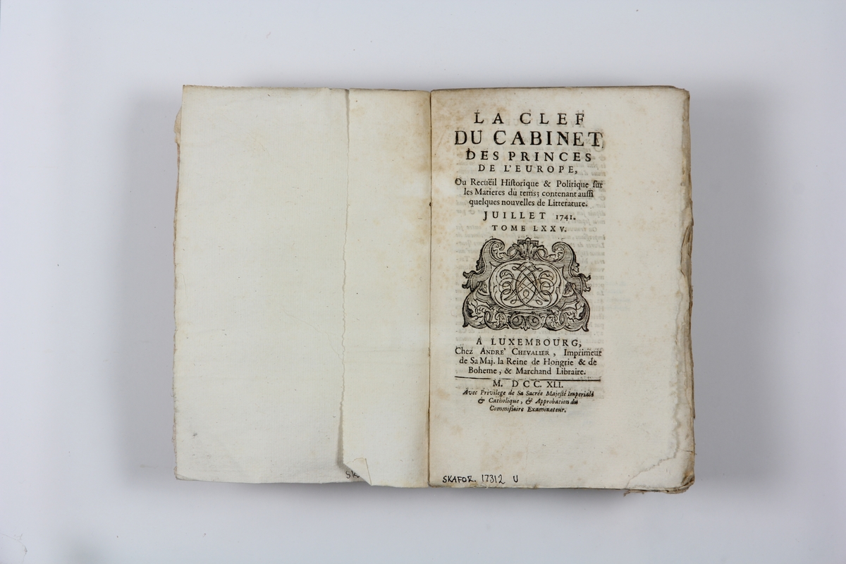Bok, pappband "La clef du cabinet des princes de
 l´Europe", del 75, tryckt i Luxemburg 1741.
Marmorerat band med blekt och skadad rygg, påklistrade pappersetiketter med titel och volymens nummer.  Med skurna snitt.