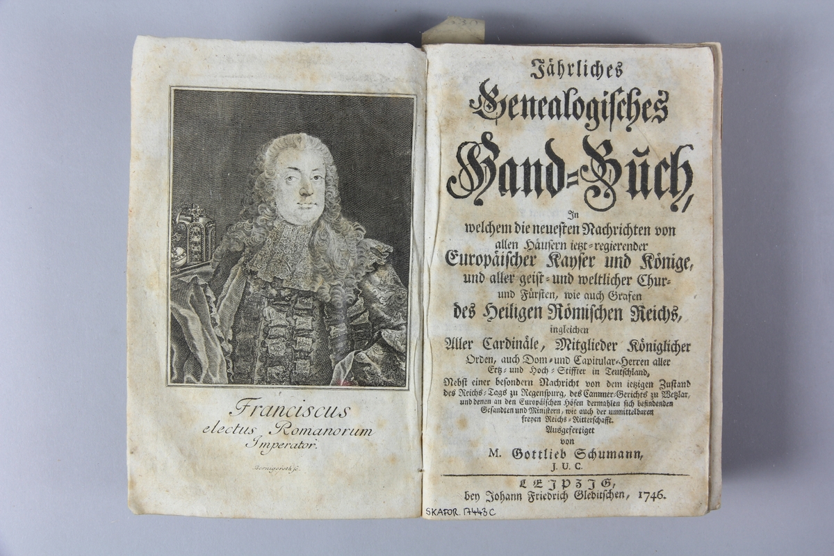 Bok, häftad, "Jährliches Genealogisches Hand-Buch", tryckt 1746 i Leipzig.
Pärm av marmorerat papper, skuret snitt. Blekt rygg med etikett med titel och samlingsnummer.