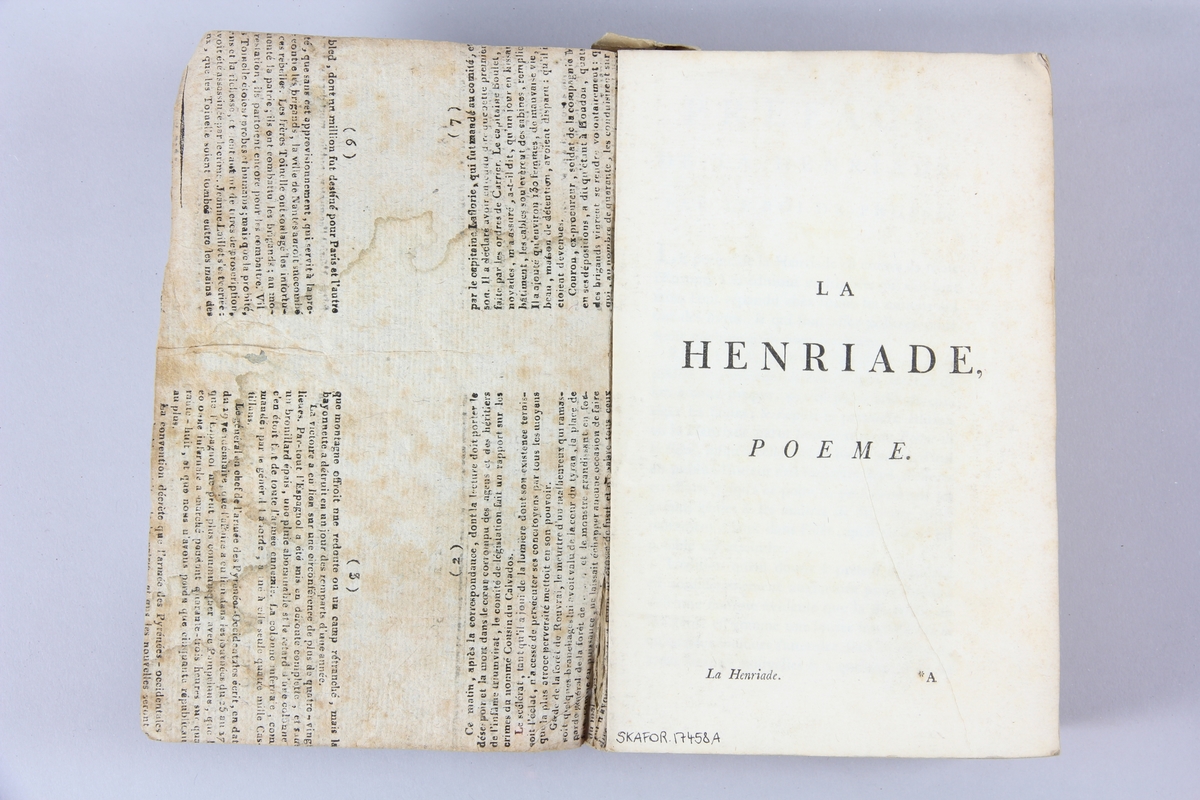 Bok, häftad,"Oeuvres complètes de Voltaire", del 10, tryckt 1785, (titelblad saknas).
Pärm av gråblått papper, på pärmens baksida klistrad sida ur annan bok. Med skurna snitt. På ryggen klistrad pappersetikett med tryckt text samt volymens nummer. Ryggen blekt.
