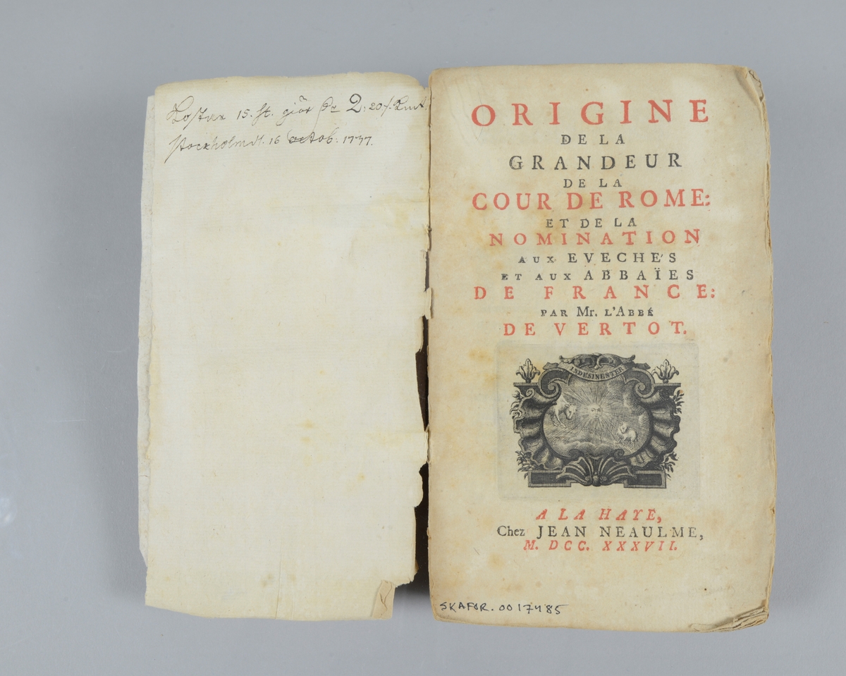 Bok, pappband, "Origine de la grandeur de la cour de Rome ", tryckt 1737 i Haag. Marmorerade pärmar, blekt rygg med etikett med till största delen utplånad text. Oskuret snitt. Anteckning om inköp på pärmens insida.
