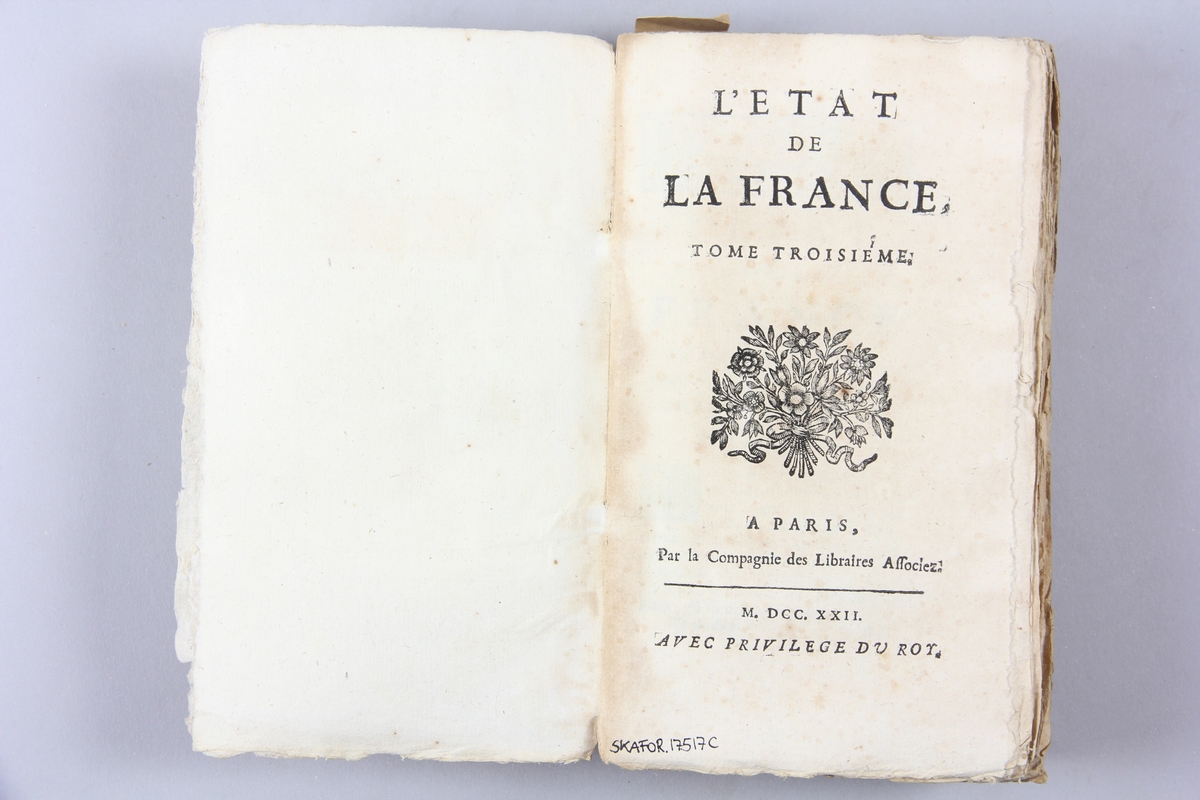 Bok, pappband, "L´Etat de France", del 3, tryckt 1722 i Paris. Marmorerade pärmar, blekt rygg med påklistrad etikett. Oskuret snitt, ej uppskuren.