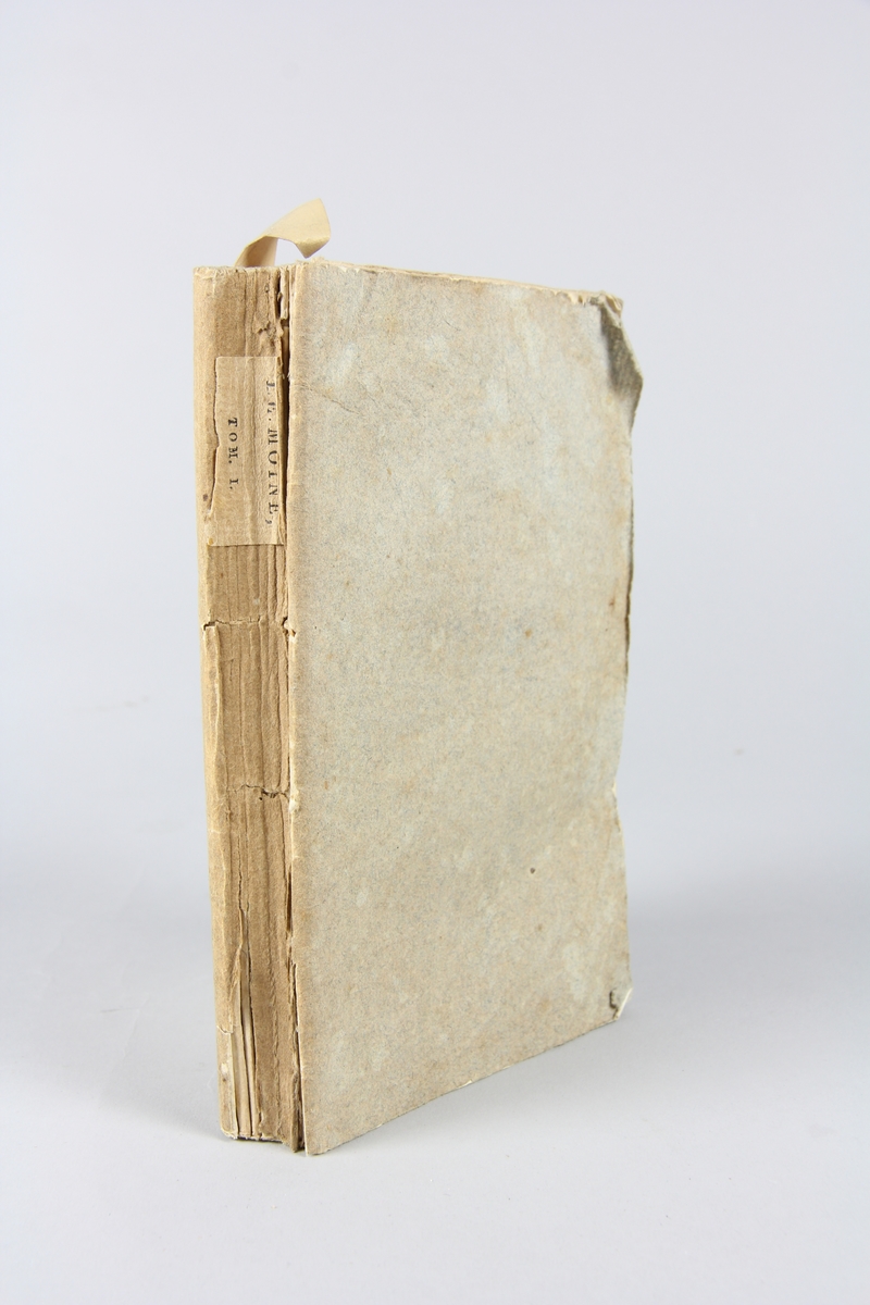Bok, häftad, "Le moine", del 1, tryckt i Paris 1797.
Pärmar av gråblått papper, skurna snitt. På ryggen tryckt etikett med volymens namn och nummer.