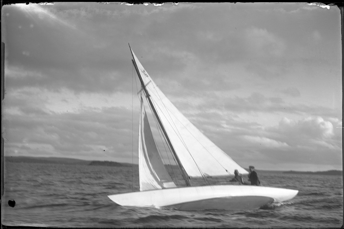 Segelbåten "Yssa" fotograferad i samband med kappsegling. Ombord syns två personer.