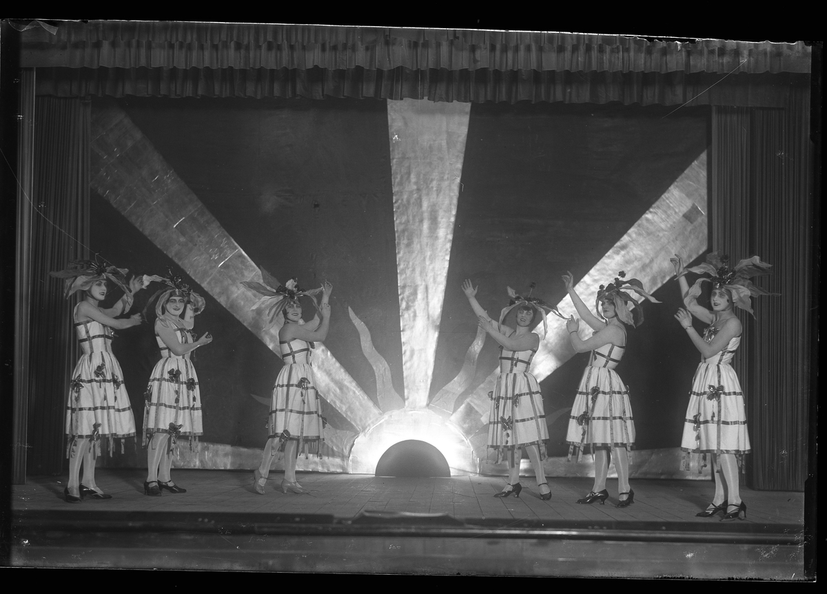 Sex kvinnor står på en scen och spelar nyårsrevy.