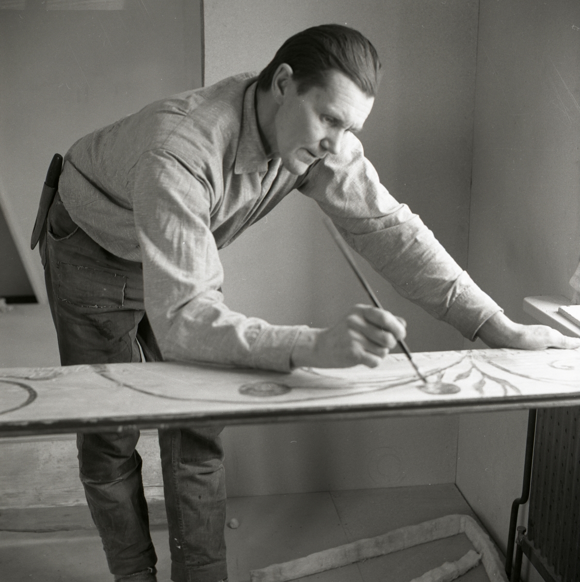 Hilding målar på en takbräda med en pensel, 1968-1969.