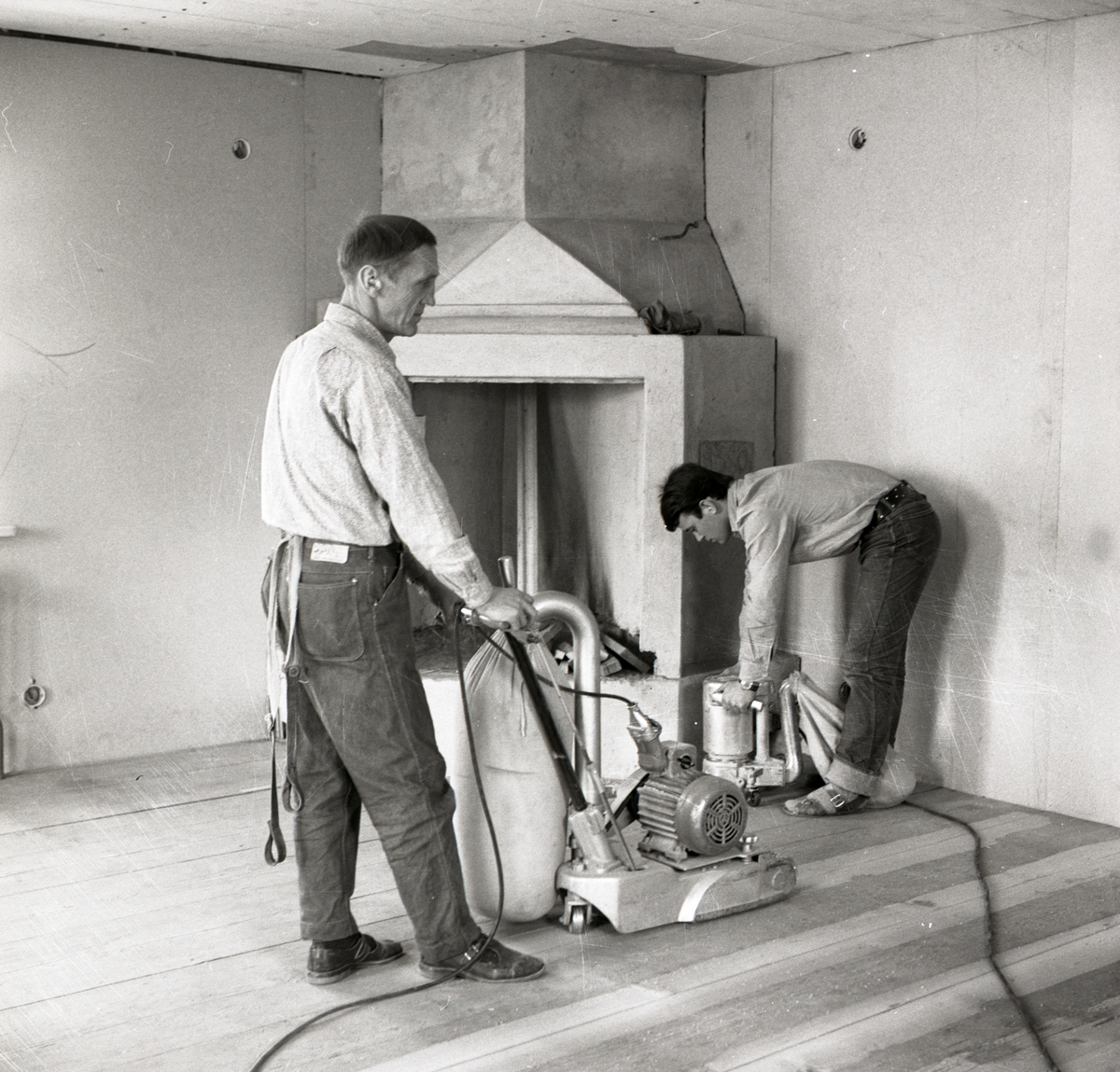 Två män slipar golvet i nya bostadshuset vid gården Sunnanåker, 1967.