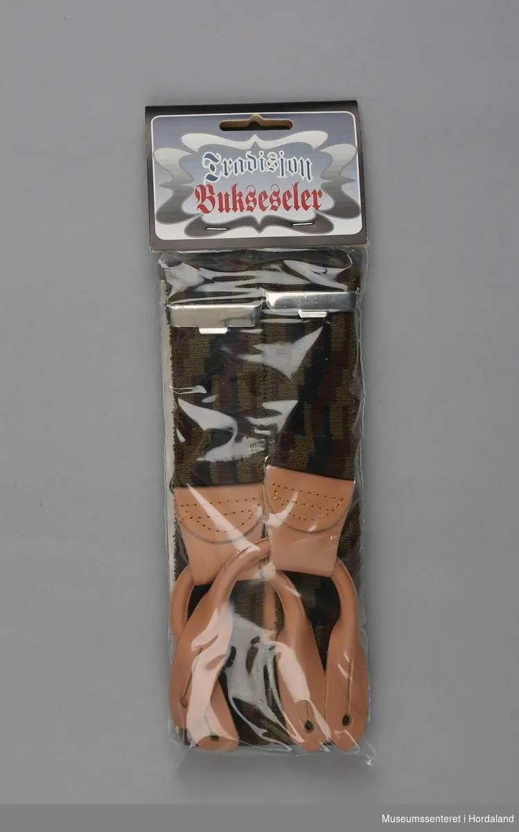 Bukeselar med skinndetaljar, "inspirert av tradisjonsrike norske mønstre", produsert ved bandfabrikken Cebelle-Trengereid i Bergen. Pakka i plastemballasje.