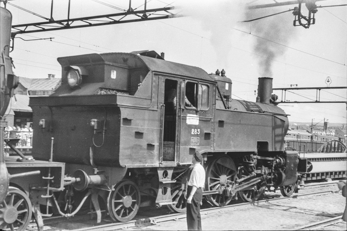Damplokomotiv type 32a nr. 283 som ekstra forspannlokomotiv i persontog på Oslo Østbanestasjon.
