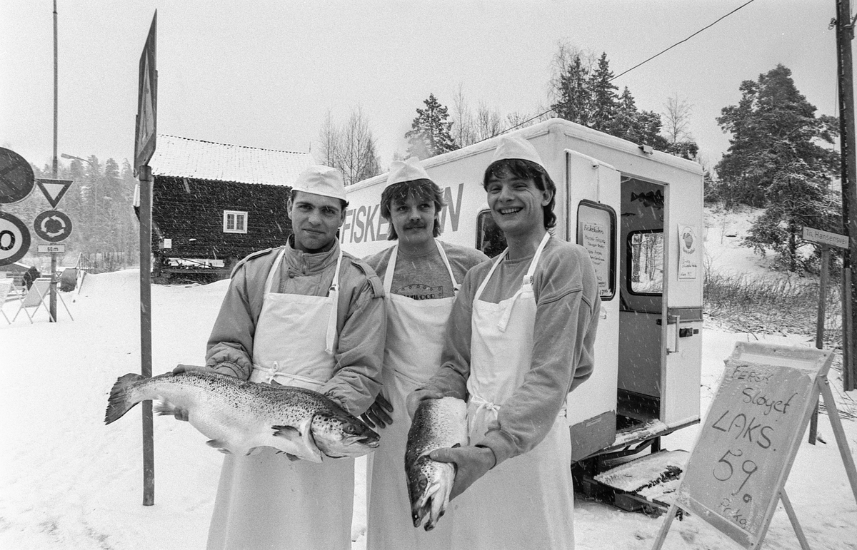 Fiskebilen i Oppegård. Tre menn står utenfor fiskebilen med laks eller ørret. Selger Atle Memo og innehaverne Tom Hille og Rino Memo.