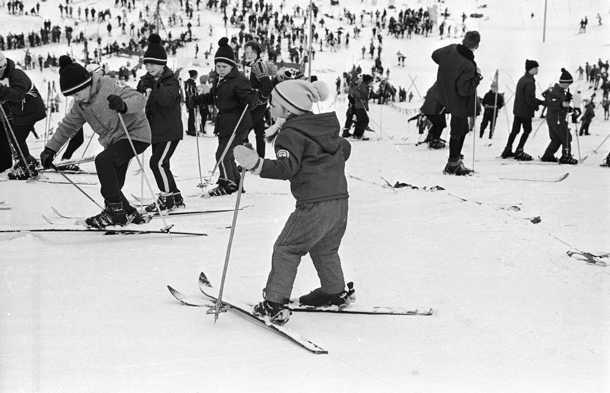 Flere barn med ski, "Aprilspøken" slalåmrenn i Tryvannskleiva. Fotografert 23. mars 1969.