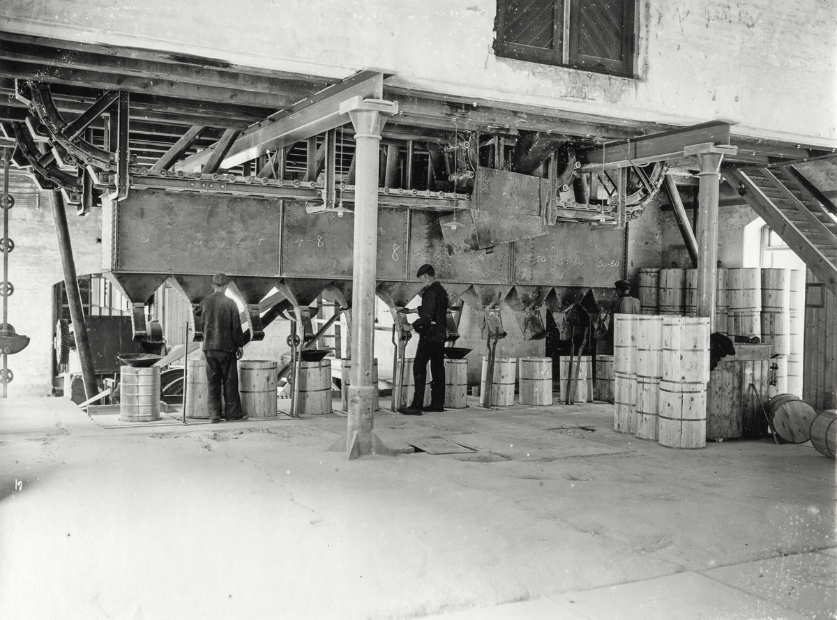 Pakking av karbid i blekkdunk med tretønner utanpå, på Oddafabrikkane i 1910.