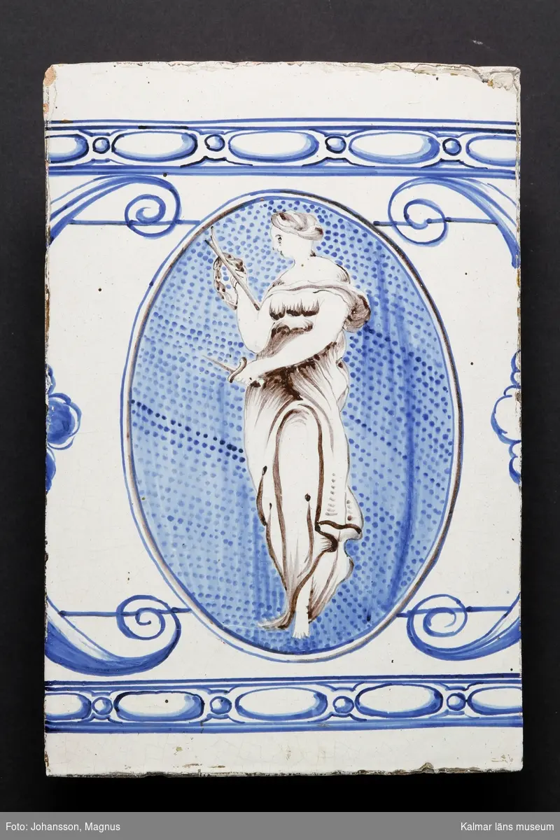KLM 9414. Kakelugn. Rund, vitglaserad med blå dekor i form av kvinnofigurer, bladrankor, mm. Av typiskt gustaviansk form, rikt dekorerad. Datering, 1790-1800. Till kakelugnen finns ett par luckor av mässing med ram samt inre luckor av järn, 36x31,5 cm.

Förteckning över samtliga kakel, med mått inom parentes, gjord i samband med inventering 1964:
:1. 29 st fasadkakel (32x22 cm)
:2. 5 st krönkakel (29x14 cm)
:3. 4 st listkakel (7x24 cm)
:4. 13 st kakelfragment