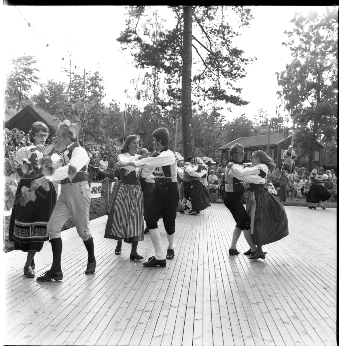 Grännapolkan på Grännaberget, 1975. Tävlingspar på dansbanan och publik runtomkring. Den manliga deltagaren bär nummerlapp på bröst och rygg.
