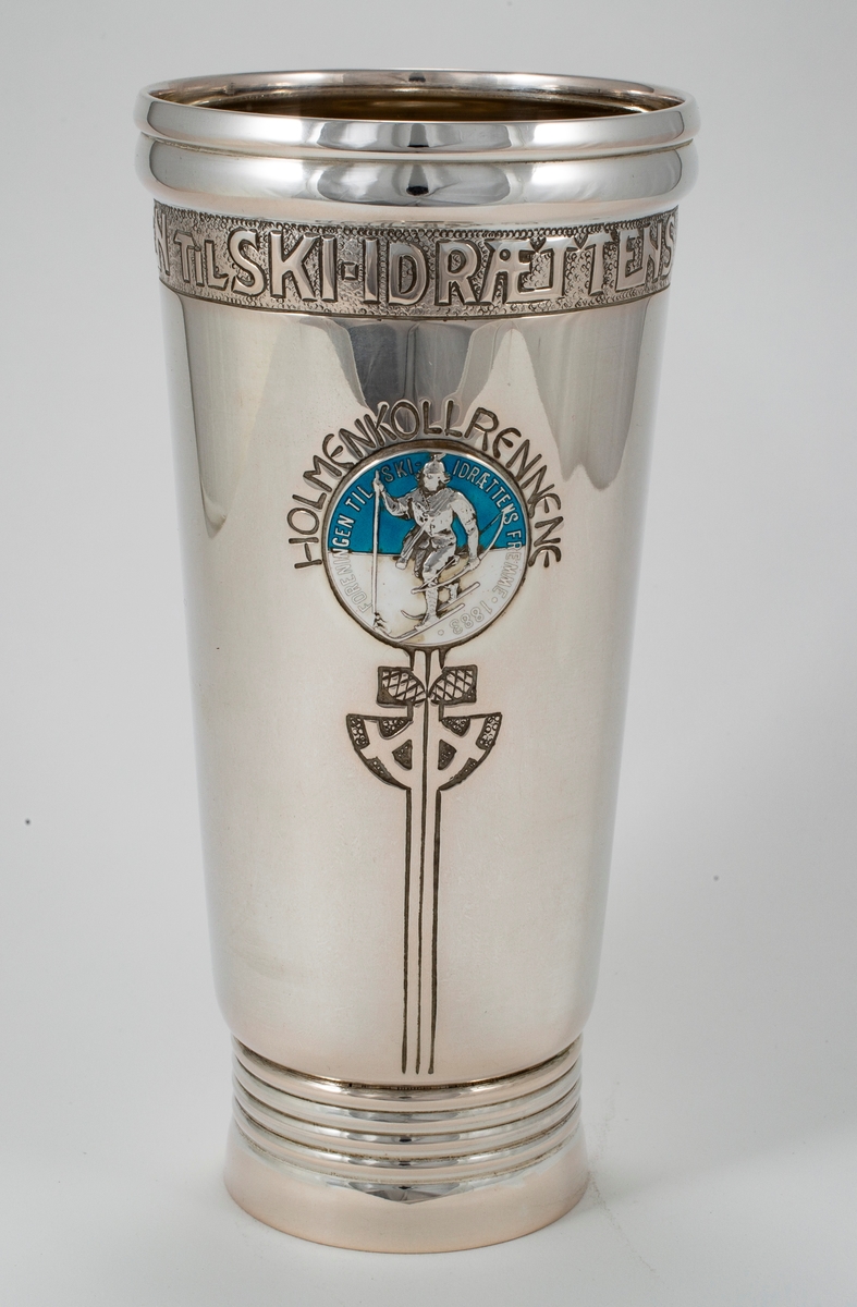 Sølvpokal med Skiforeningens emblem i blått og hvitt.