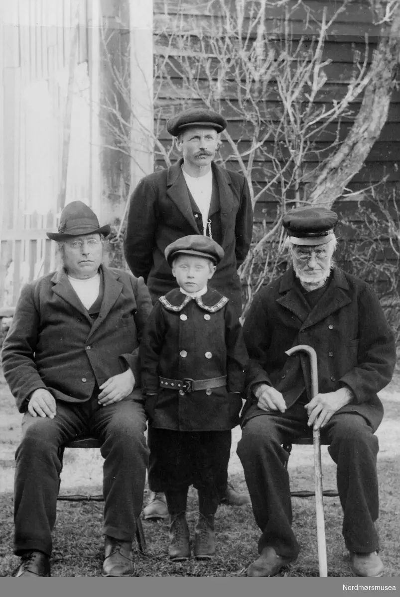 Foto av tre menn og en liten gutt. Fra Fru Williams fotoalbum. Eier av originalmaterialet er Gunnar Williams. Fra Nordmøre museums fotosamlinger.