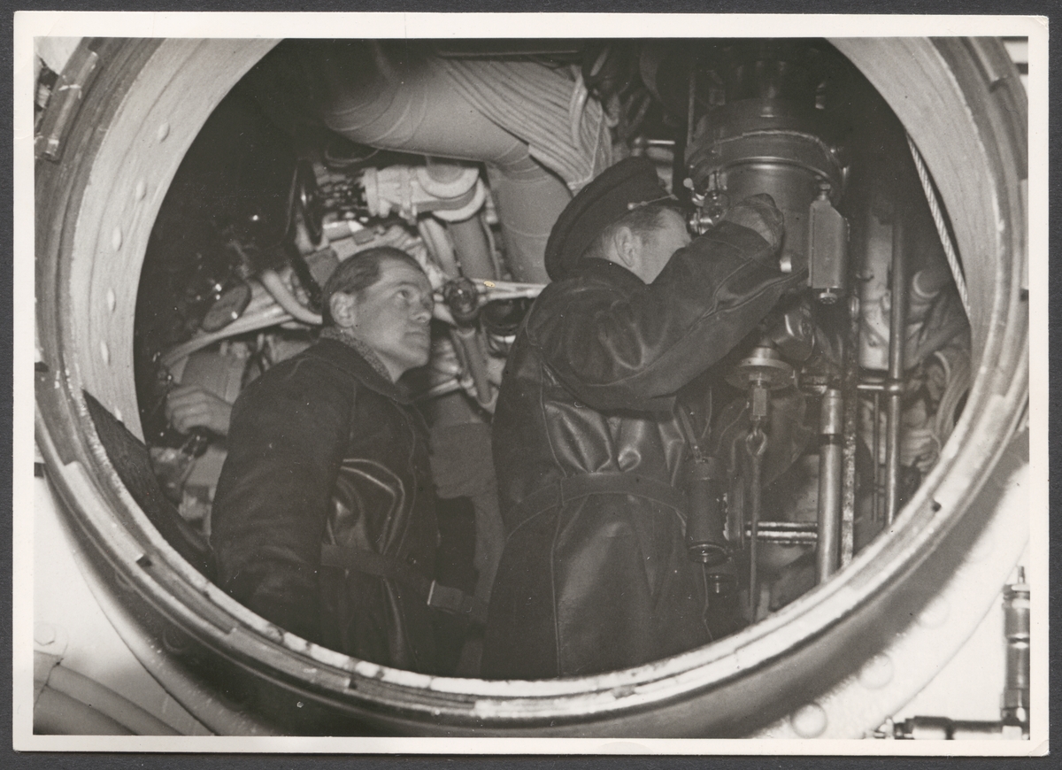 Motiven föreställer blicken genom en ubåtsskott in i manöverrummet där en besättningsman håller på att titta genom periskopet.