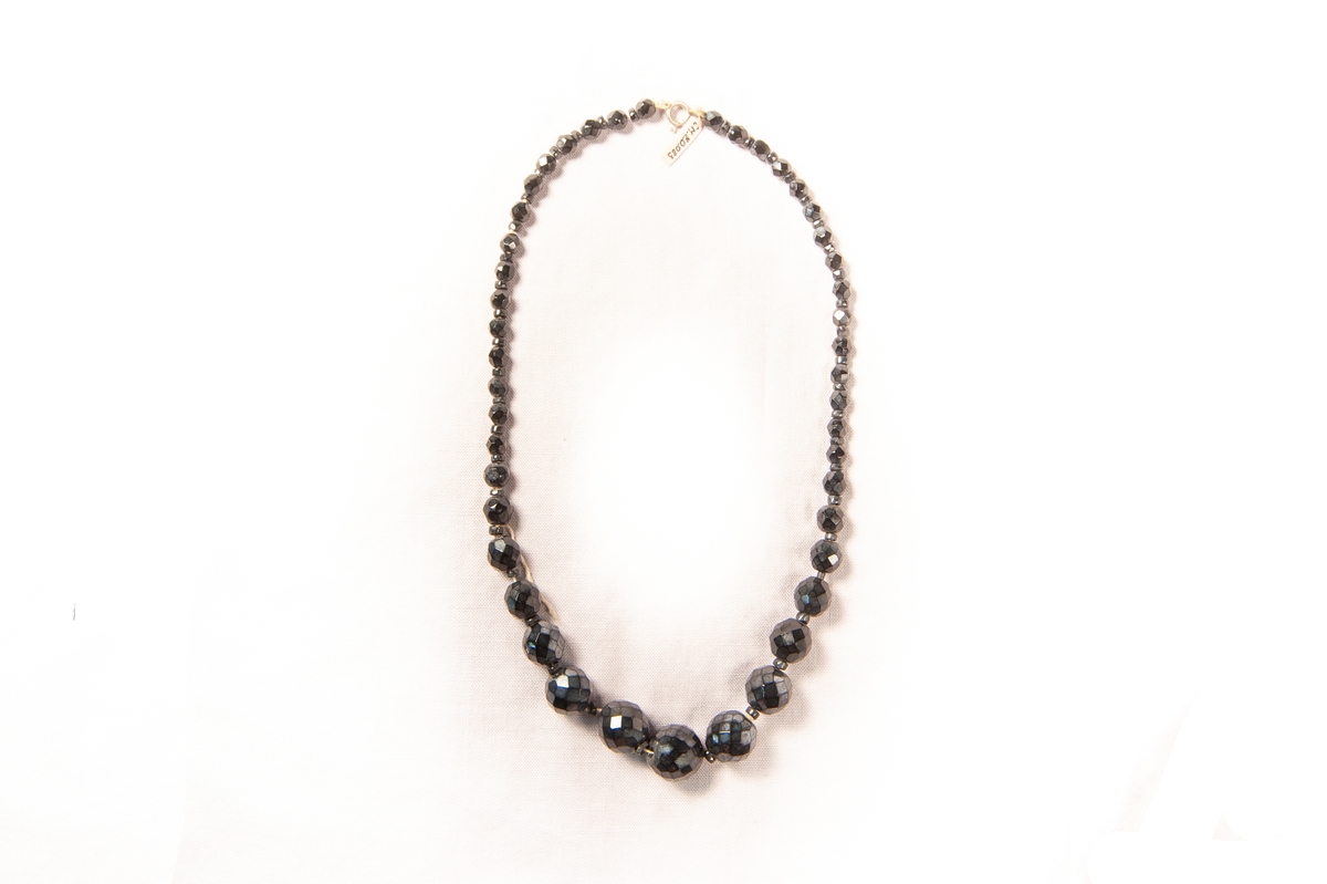 Halsband av svarta, fasettslipade stenkolspärlor i doserande storlek.