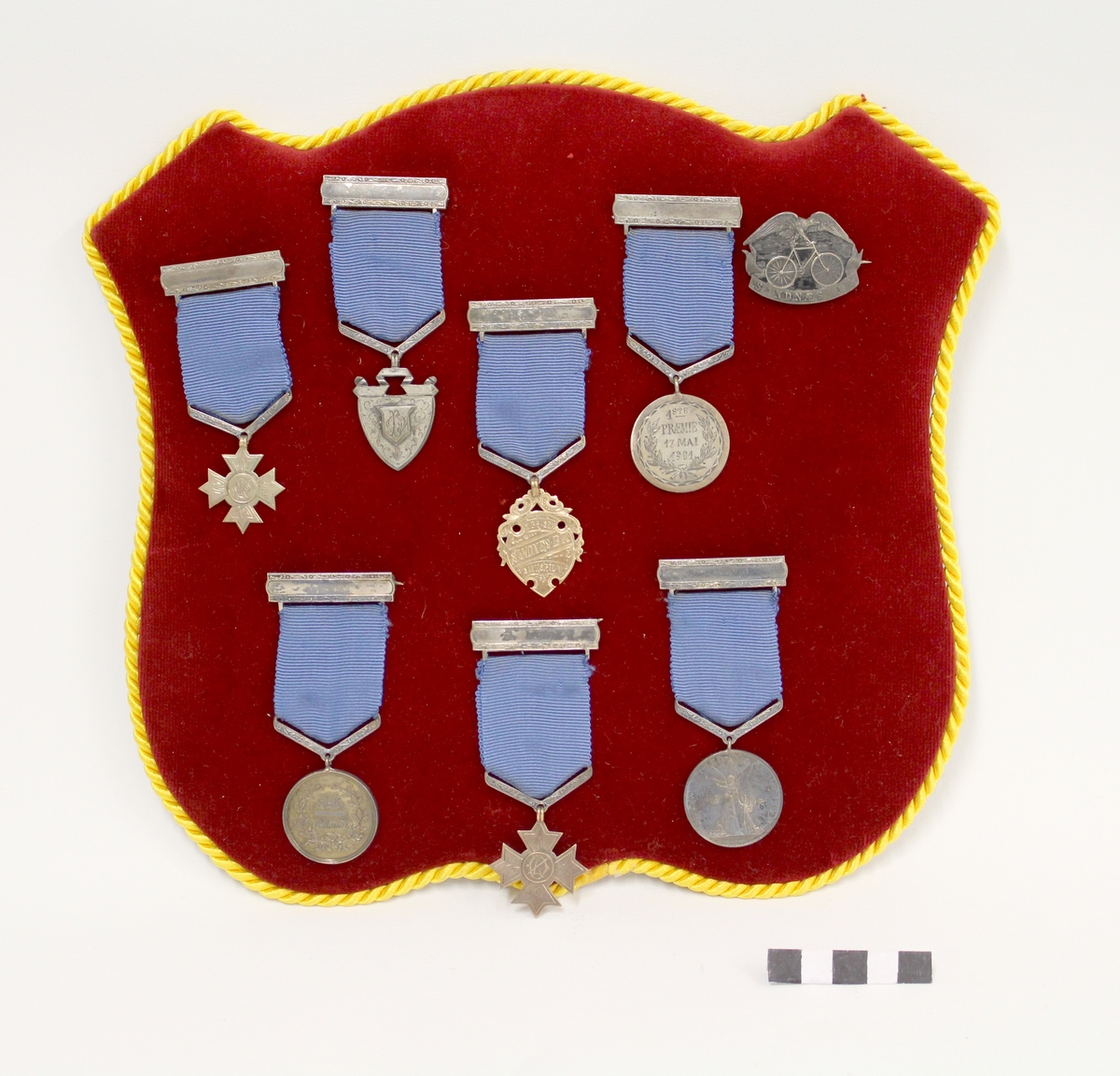 Åtte medaljer montert på fløyelskledd merkeskjold. Medaljesamling etter Lars Øglænd.