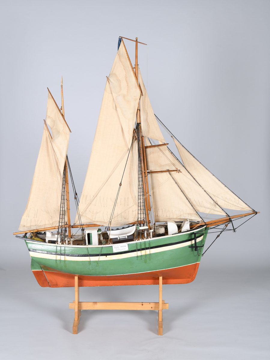 Båtmodell av en galeas med klyverbom og to master. Seilene er utslått. Flere detaljer, blant annet en livbåt på dekk og et anker som hviler på skipets frontside.


Modellen hviler på et stativ av treverk.
