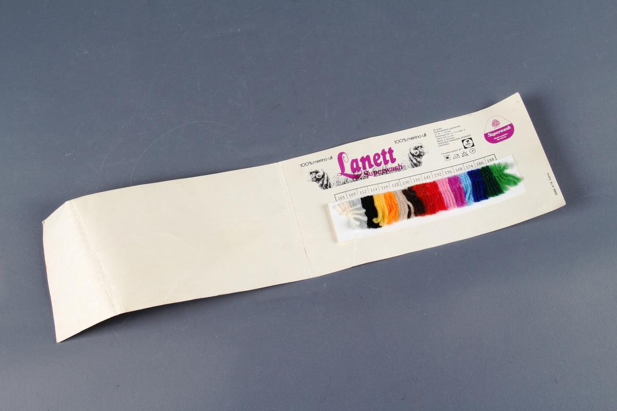 Garnprøver i forskjellige farger innlimt i en papirfolder.