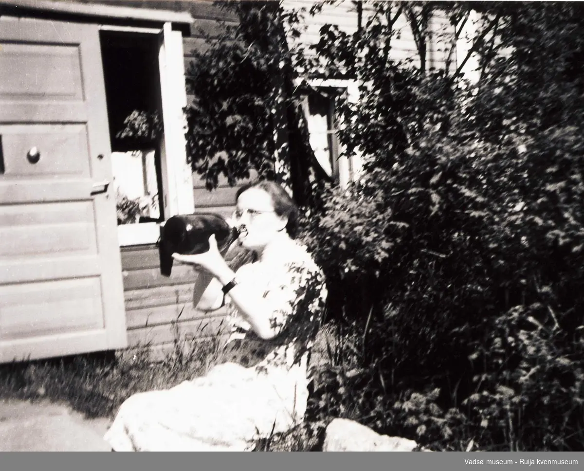 Ida Tuomainen på ferie i Finland. Drikker av flaska. Ca 1950-tallet.