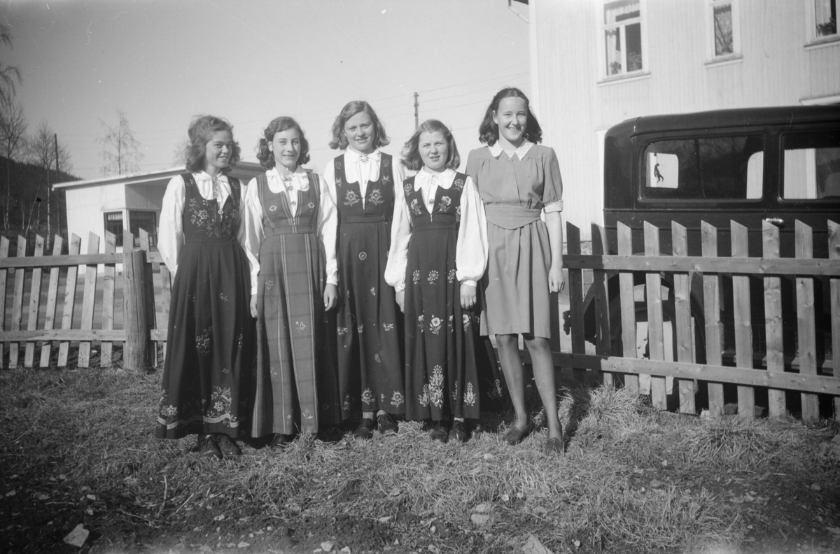Gruppebilde av fem festkledde, unge jenter på eiendommen Vie, tilhørende Birger Børresen, ved Vestre Gausdal Handelsforening